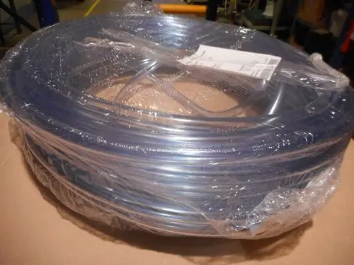 Verpackte PVC-Rohre, möglicherweise von Remeha, die auf einem Karton hinterlegt sind. Sichtbare Teile zeigen eine transparente und flexible Struktur.